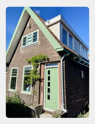 a brick house with a green door on it at House next to Amsterdam in Landsmeer