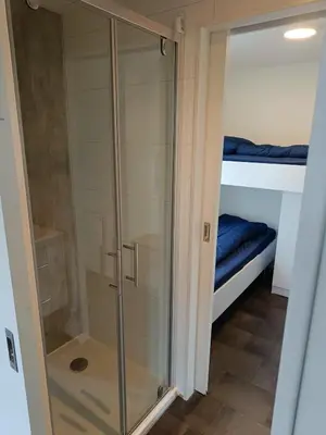 a glass shower in a room with a bed at Holiday home - area AMSTERDAM - 6 people in Halfweg