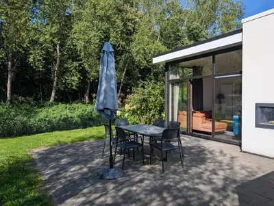 a patio with a table and chairs and an umbrella at Holiday home - area AMSTERDAM - 6 people in Halfweg