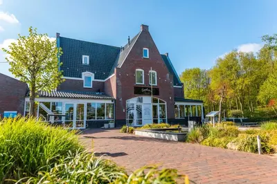 a large brick building with a brick driveway at Holiday home - area AMSTERDAM - 6 people in Halfweg