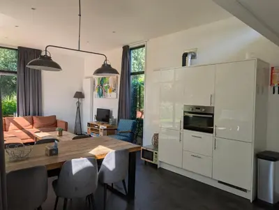 a kitchen with a table and a dining room at Holiday home - area AMSTERDAM - 6 people in Halfweg