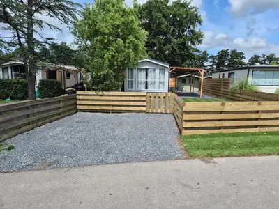 a wooden fence in front of a house at Chalet 549 op Recreatiepark de Wielen in Sint Maarten