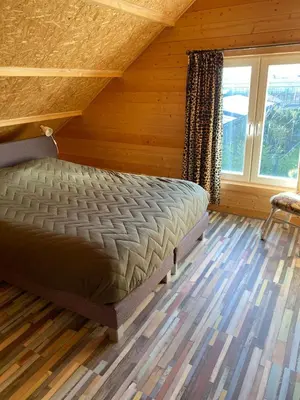 a bedroom with a bed in a wooden room at The blue house in Roelofarendsveen
