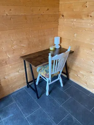 a wooden table with a chair and a wooden wall at The blue house in Roelofarendsveen