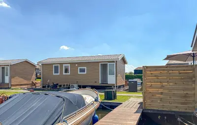 a small boat is docked next to a house at Gorgeous Home In Breukelen With House Sea View in Breukelen