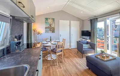 a kitchen and living room with a table and a couch at Gorgeous Home In Breukelen With House Sea View in Breukelen