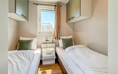 two beds in a small room with a window at Gorgeous Home In Breukelen With House Sea View in Breukelen