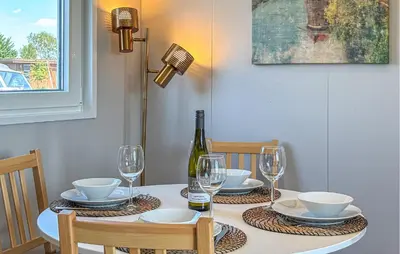 a dining room table with a bottle of wine and glasses at Gorgeous Home In Breukelen With House Sea View in Breukelen