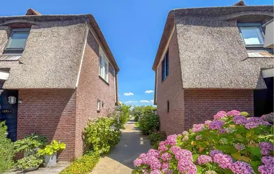 two brick buildings with flowers in front of them at Gorgeous Home In Breukelen With House Sea View in Breukelen