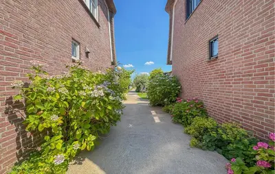 a pathway between two brick buildings with flowers at Nice Home In Breukelen in Breukelen