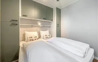 a bedroom with a bed with white sheets and pillows at Nice Home In Breukelen in Breukelen