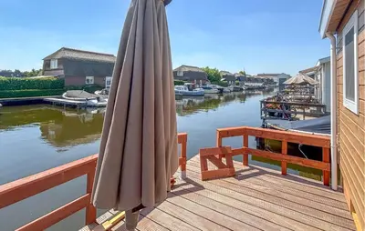 an umbrella sitting on a deck next to a river at Nice Home In Breukelen in Breukelen