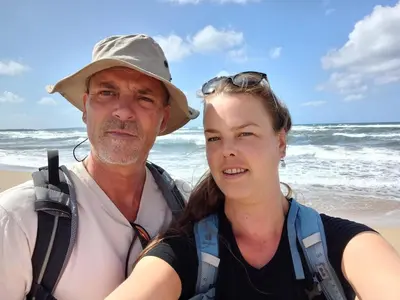 a man and a woman standing on the beach at Chalet with waterfront sauna and boat in Loosdrecht