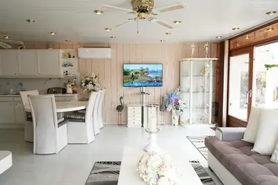 a kitchen and living room with a couch and a table at Chalet with waterfront sauna and boat in Loosdrecht