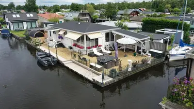 an aerial view of a house on a dock in the water at Chalet with waterfront sauna and boat in Loosdrecht