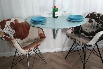 a table with two chairs and a bottle of wine at Eeden in Noordwijk aan Zee