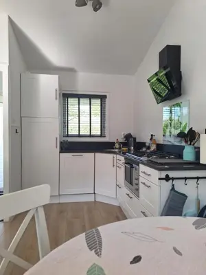 a kitchen with white cabinets and a white refrigerator at Rekerlanden 133 in Warmenhuizen