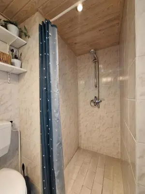 a shower with a shower curtain in a bathroom at Rekerlanden 133 in Warmenhuizen