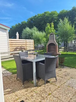 a patio with a table and chairs and a grill at Rekerlanden 133 in Warmenhuizen