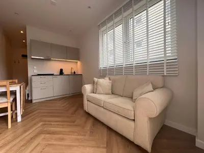 a living room with a couch and a kitchen at The Dune house, Free parking in Zandvoort