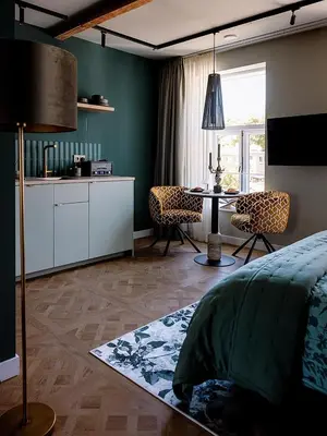 a bedroom with a kitchen and a dining room with a table at Suites aan de Gracht Utrecht in Utrecht