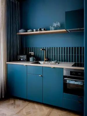 a blue kitchen with a sink and a stove at Suites aan de Gracht Utrecht in Utrecht