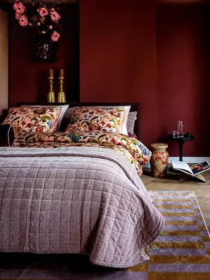 a bedroom with a bed with a blanket on it at Suites aan de Gracht Utrecht in Utrecht