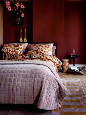a bedroom with a bed with a blanket on it at Suites aan de Gracht Utrecht in Utrecht