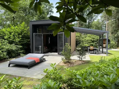 a modern house in a garden with a couch at Samoza in Ons Belang