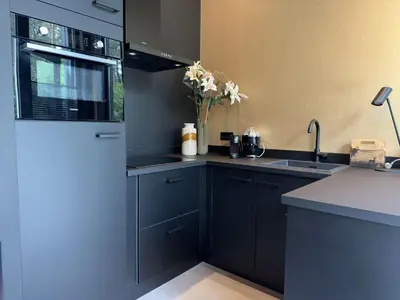 a kitchen with blue cabinets and a vase of flowers at Samoza in Ons Belang