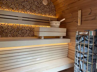 a sauna with wood paneling and a shelf with logs at Samoza in Ons Belang