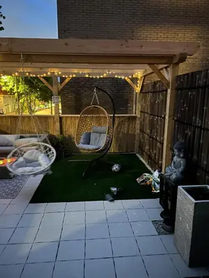 a backyard with a swing and a hammock under a pergola at Paleisje aan zee in IJmuiden