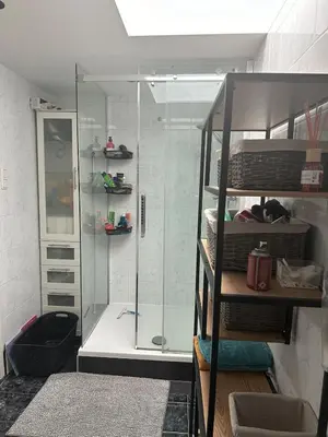 a shower with a glass door in a room at Paleisje aan zee in IJmuiden