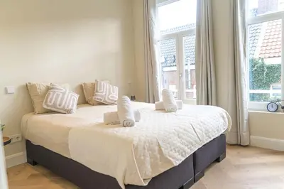 a bedroom with a large bed with white sheets and pillows at Charming Jordaan Apartment, Canal Views in Amsterdam