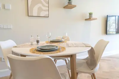 a dining room table with white chairs and a white table with glasses at Charming Jordaan Apartment, Canal Views in Amsterdam