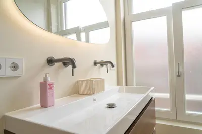 a bathroom with a white sink and a mirror at Charming Jordaan Apartment, Canal Views in Amsterdam