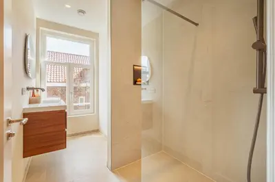 a bathroom with a shower with a glass door at Charming Jordaan Apartment, Canal Views in Amsterdam