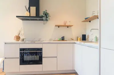 a kitchen with white cabinets and a fireplace at Charming Jordaan Apartment, Canal Views in Amsterdam