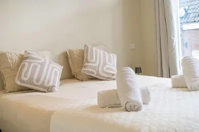 a white bed with white pillows on top of it at Charming Jordaan Apartment, Canal Views in Amsterdam
