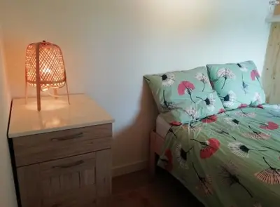 a bedroom with a bed and a nightstand with a lamp at Guesthouse Het Woerdense Veerhuis in Woerden