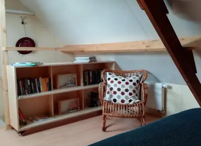 a room with a chair and a book shelf at Guesthouse Het Woerdense Veerhuis in Woerden