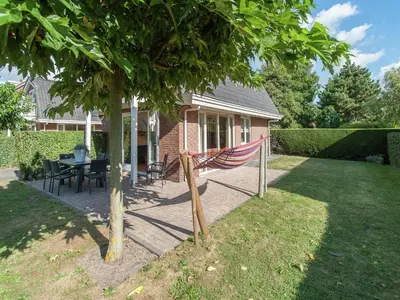 a hammock in a yard next to a house at Holiday Home near Dutch Coast & Forest in Noordwijk