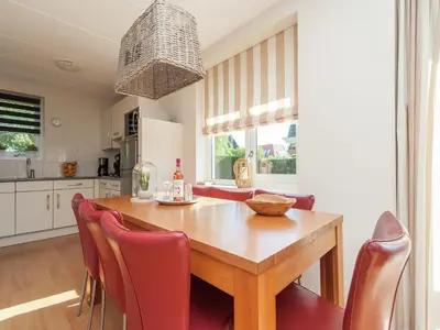 a kitchen and dining room with a wooden table and chairs at Holiday Home near Dutch Coast & Forest in Noordwijk