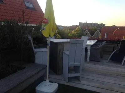 an umbrella and a table and chairs on a deck at Holiday apartment in Alkmaar in Alkmaar