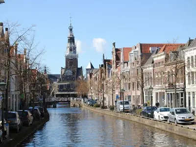 a river in a city with cars parked next to buildings at Holiday apartment in Alkmaar in Alkmaar