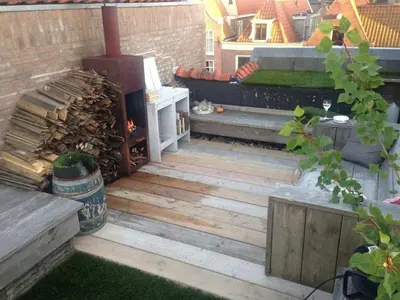 a backyard patio with a woodburning grill and benches at Holiday apartment in Alkmaar in Alkmaar