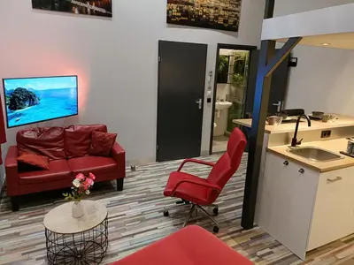 a living room with a red couch and a sink at Stijlvolle Designstudio in Almere