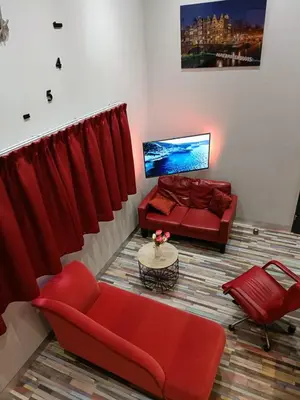 a living room with red furniture and a couch at Stijlvolle Designstudio in Almere