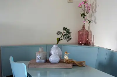 a table with vases and flowers on top of it at die Perle in Zandvoort