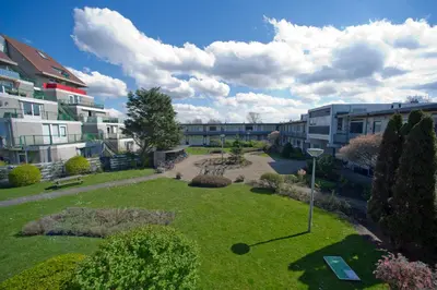 an apartment complex with a garden in the middle of a park at die Perle in Zandvoort